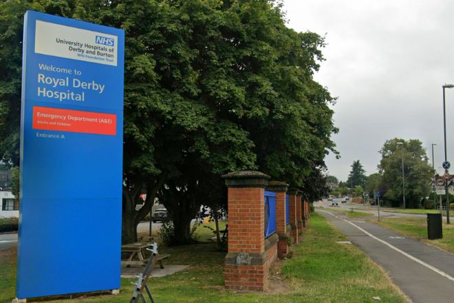 Large blue roadside sign for Royal Derby Hospital.