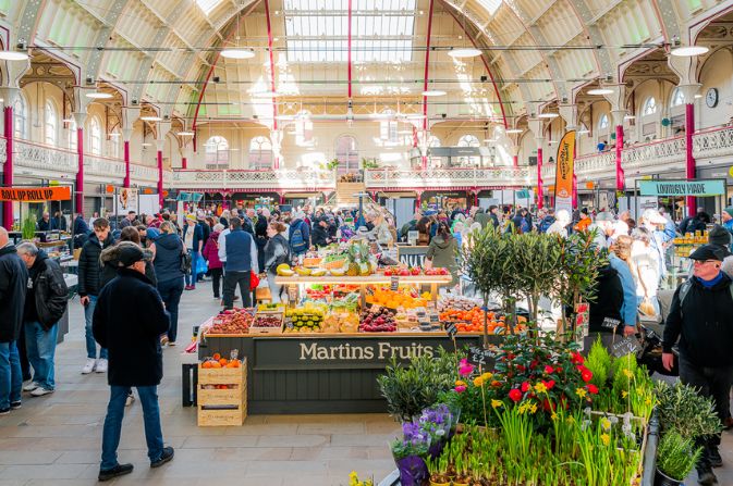 The inside of Derby Market Hall with bustling stalls under the iconic roof