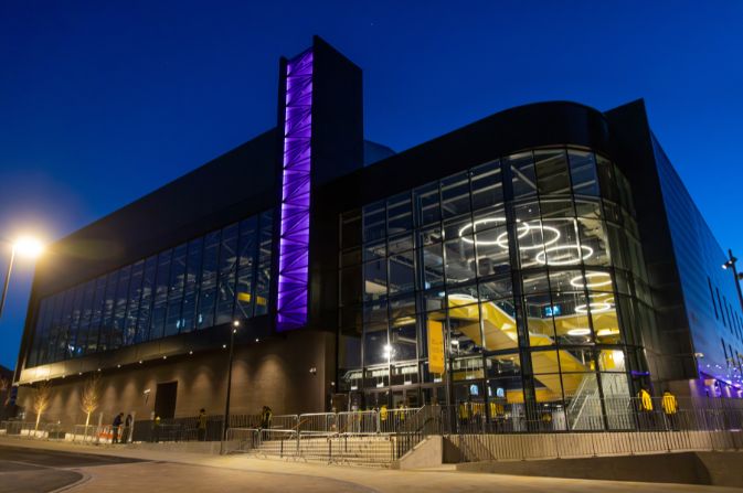 a large modern building with a glass fronted foyer at night.