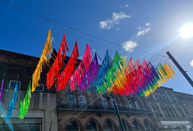 Colourful rainbow canopy art installed above shoppers heads in Iron Gate