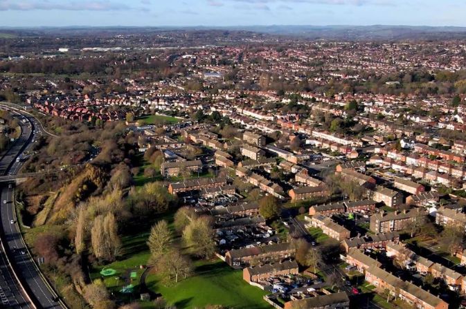 An aerial view of a residential area with a dual carriageway running on one side.