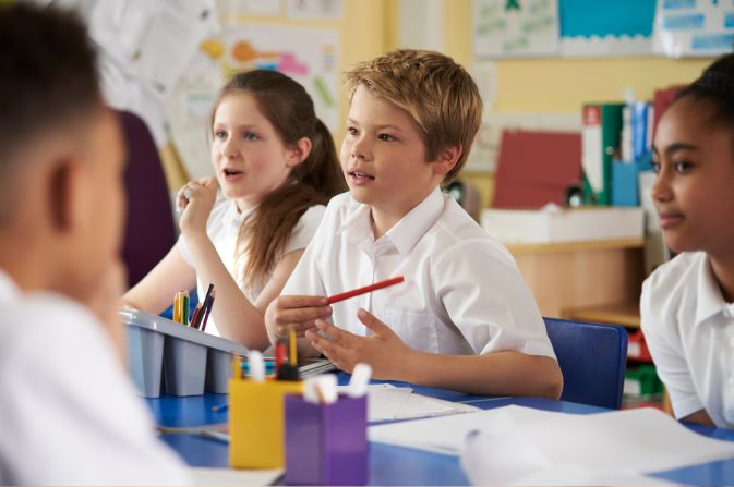 Primary school aged children sitting at school desks