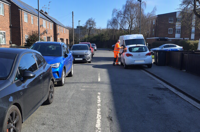 A street in Derby, blocked by parked cars.