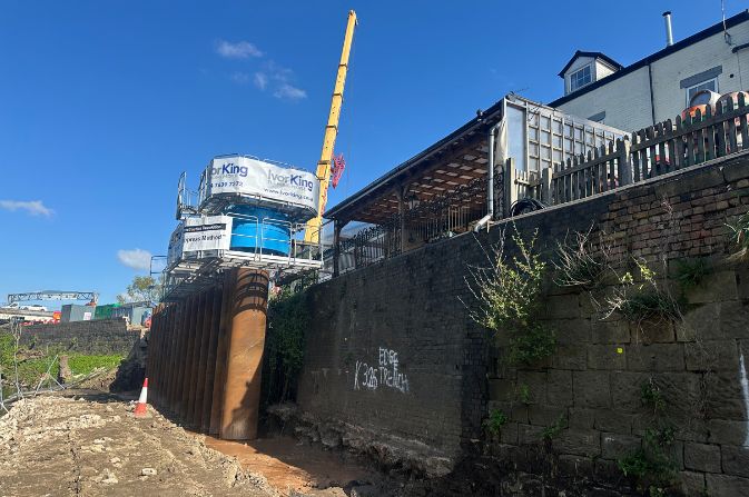 A large piling machine sat on top of tall concrete piles.