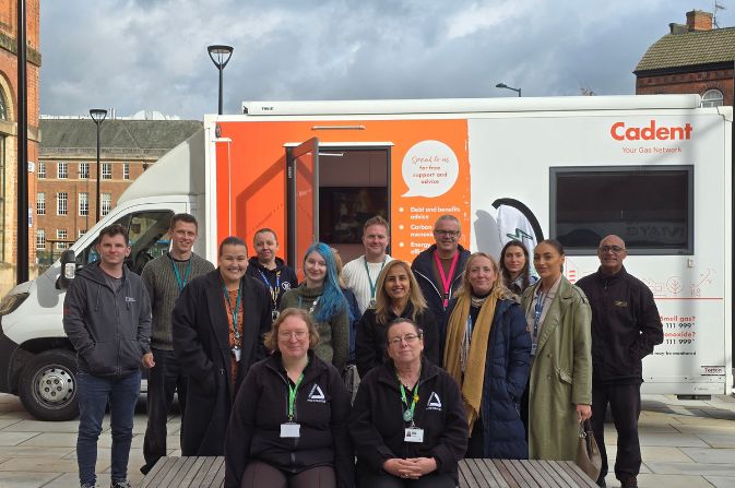 A group of people in front of a white van with orange stickers