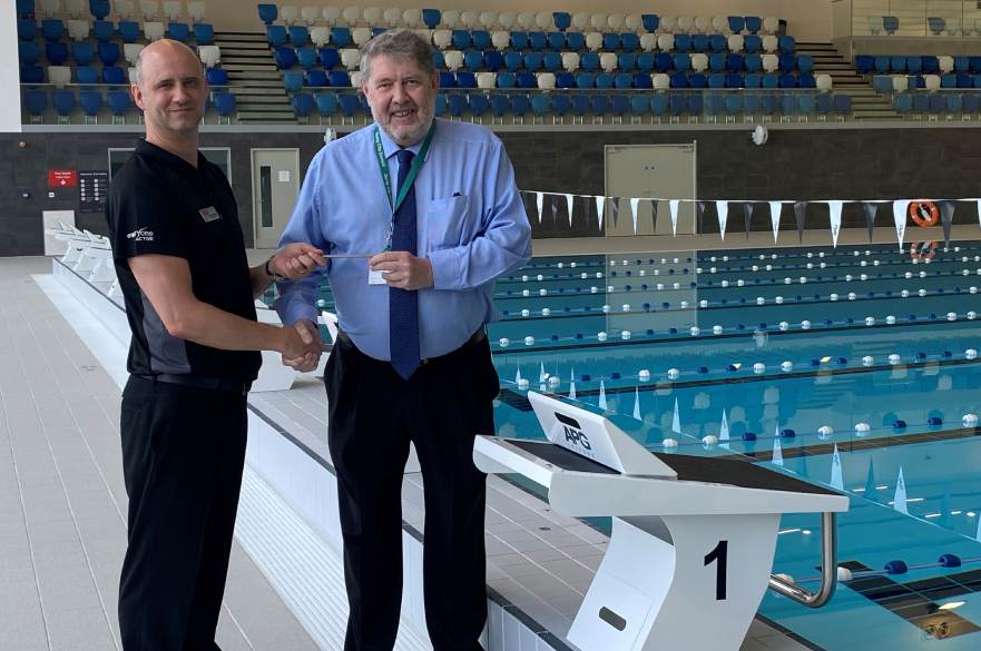 Cllr Chris Poulter hands over the key to Moorways Sports Village to Simon Morgan, Contract Manager for Everyone Active