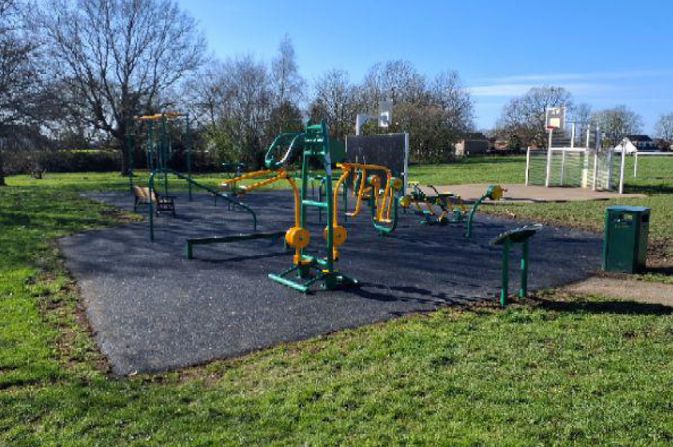 Outdoor gym equipment located in a sunny park