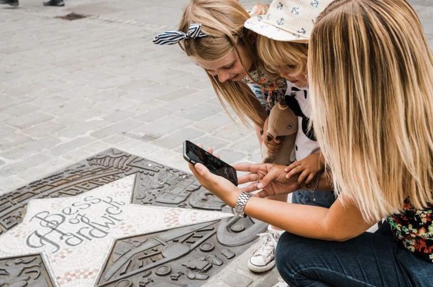 Parent and child taking photo of star plaque