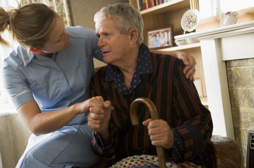 An older man is comforted by a home carer