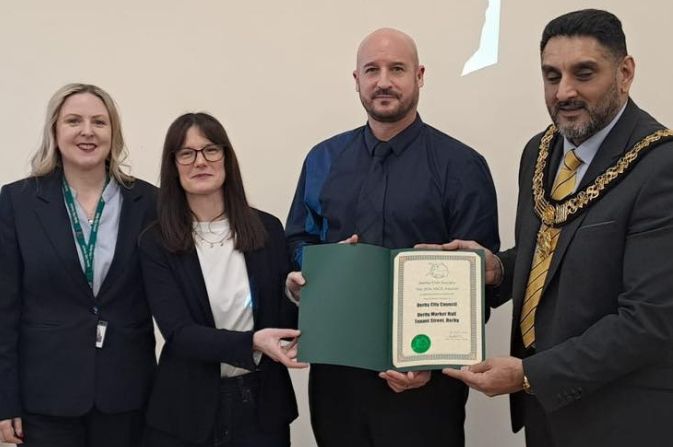 Three  people accepting an award from the mayor