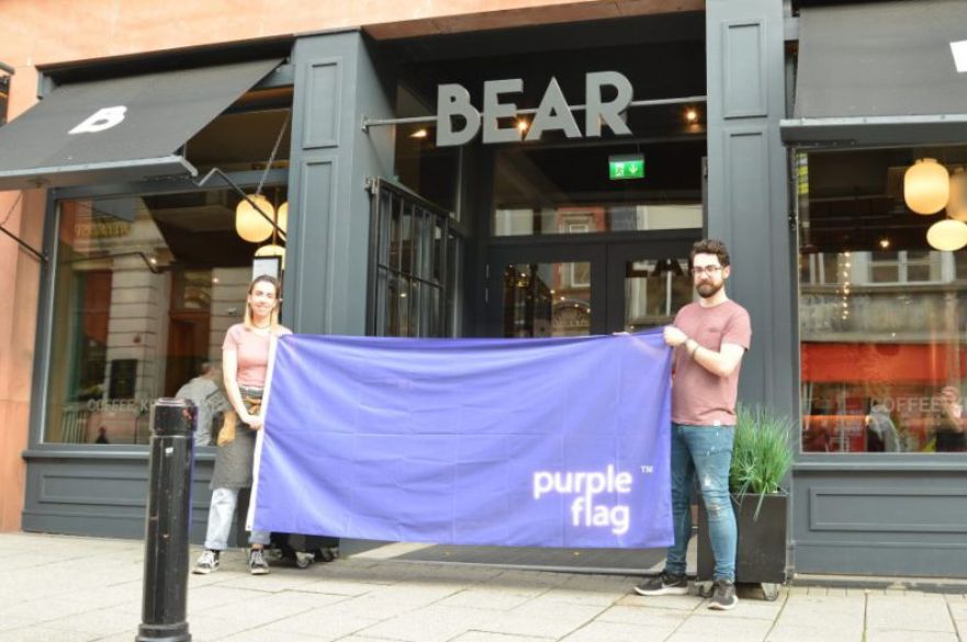 Bear Cafe staff holding purple flag