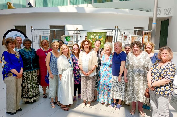 A group of carers and support staff at an exhibition of carers' art