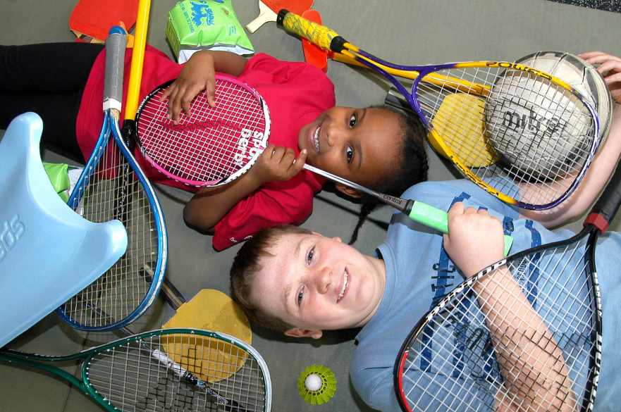 Two boys with racquets in a sports centre