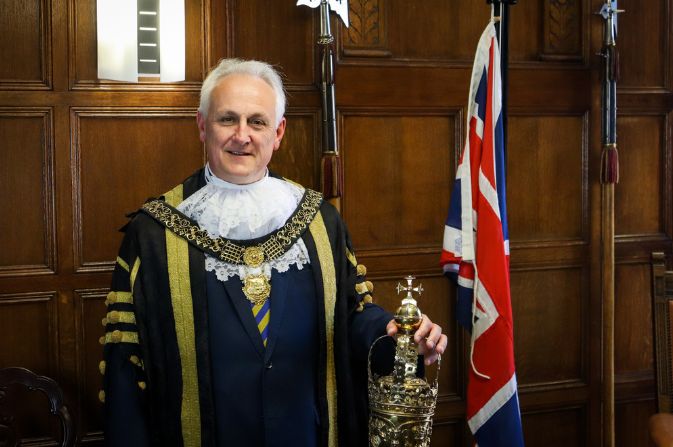 Mayor of derby Alan Graves in black and gold robes holding mace.