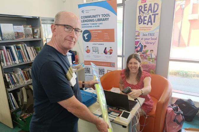 A customer at a service desk being served by a lady who is scanning an object.