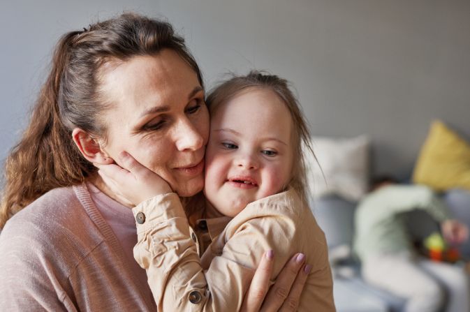 Adult hugging a child.