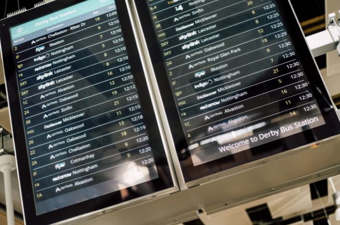 Digital displays showing a number of bus times at Derby Bus Station.