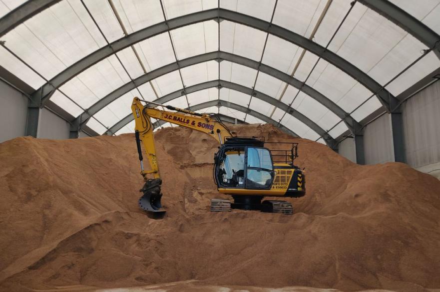 excavator on mound of grit salt in Stores Road depot